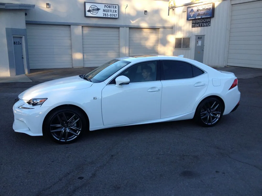 White sedan parked in front of commercial garage doors and business signage