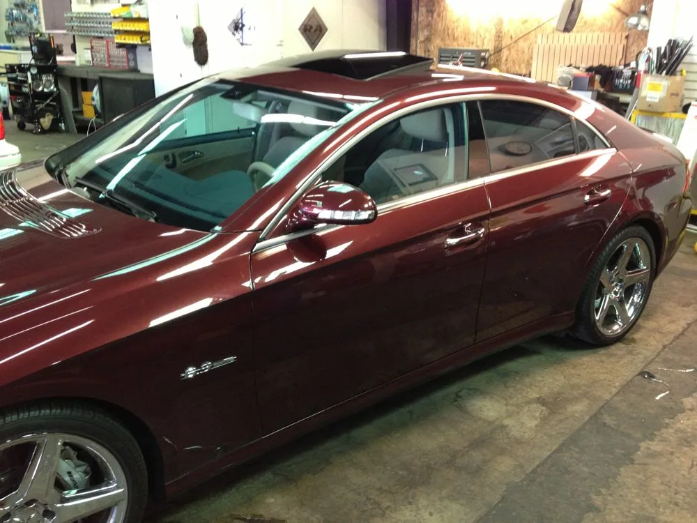 Burgundy sedan with tinted windows parked in auto shop garage