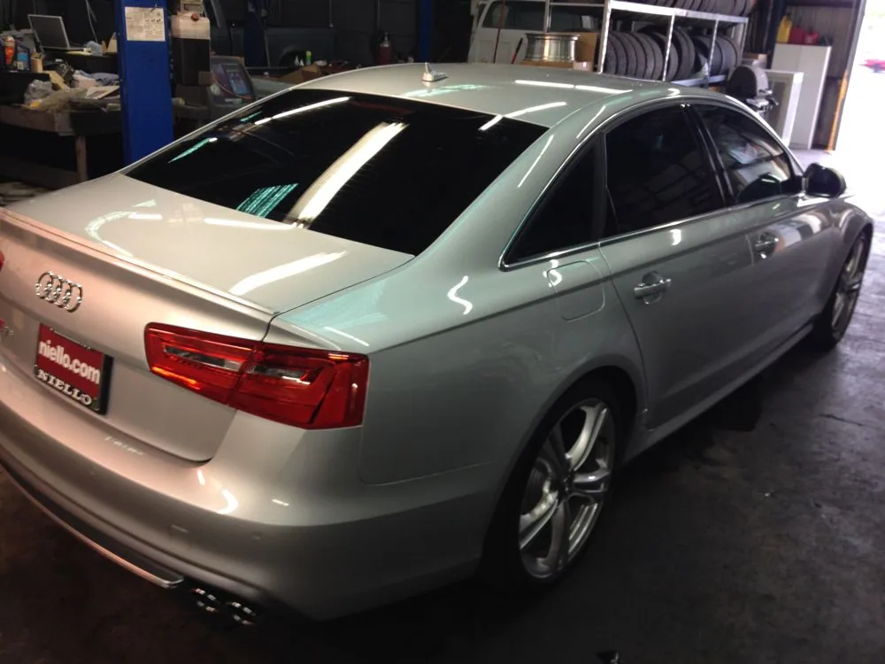 Silver sedan with tinted windows displayed in a showroom